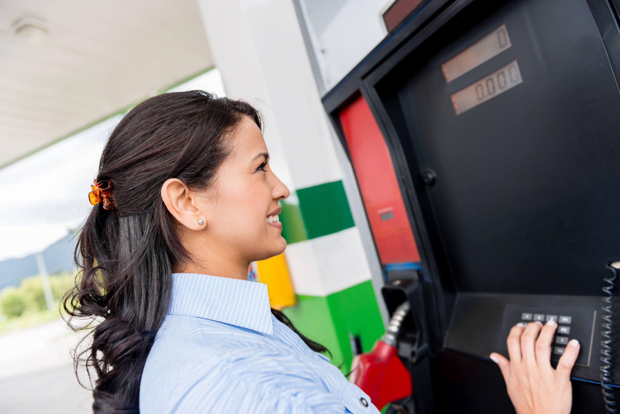 A fleet driver preparing to pay for her gas at the pump with a fleet card.