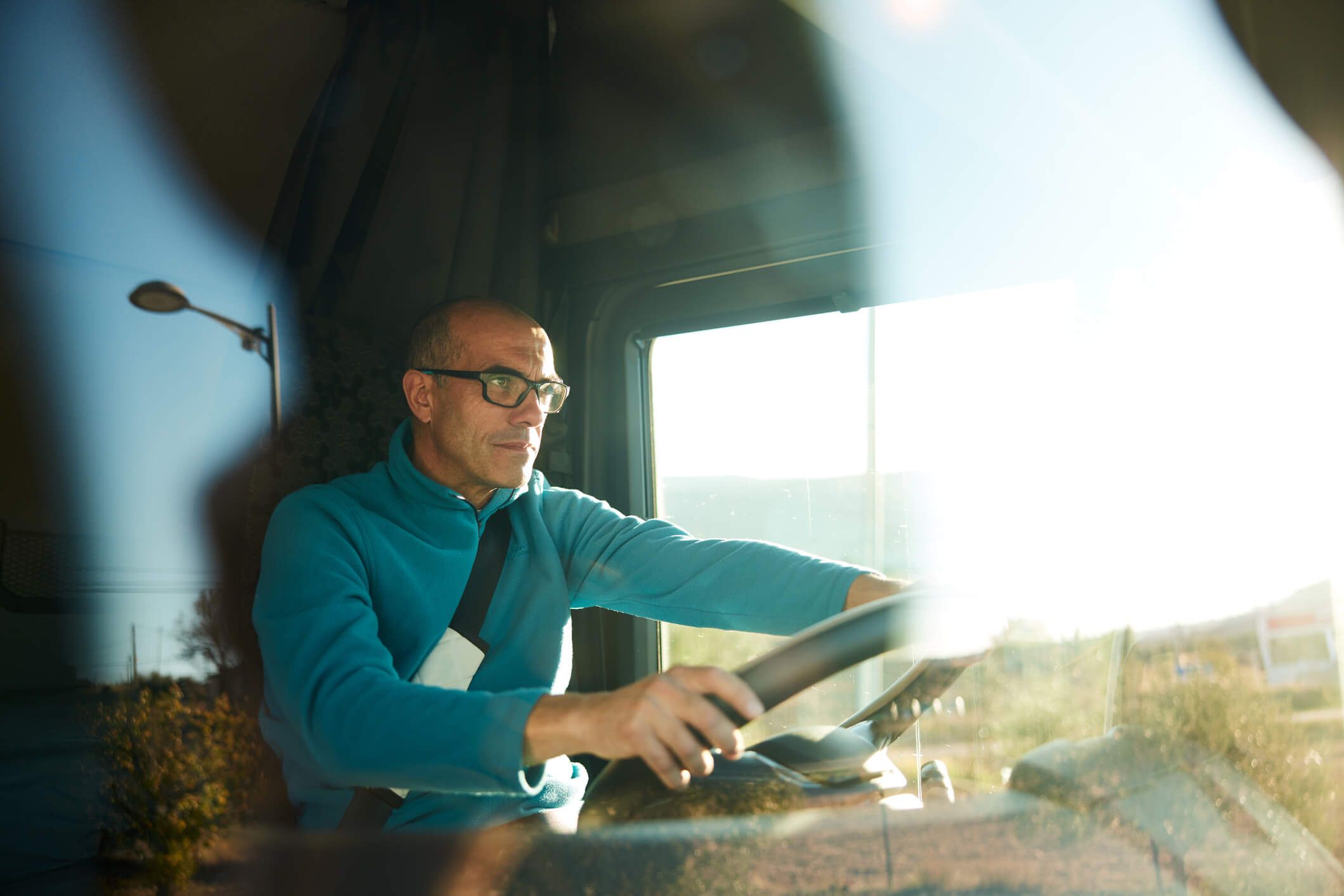 A truck driver navigating his semi on the highway.