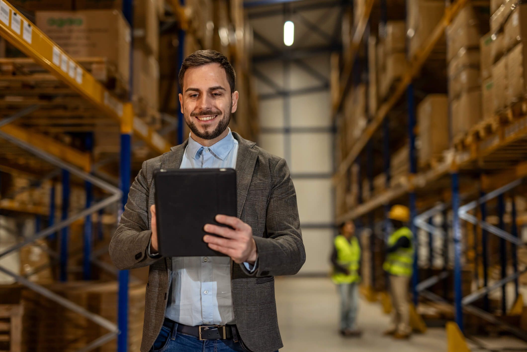 A fleet owner checks his fuel card analytics in his warehouse on his tablet.
