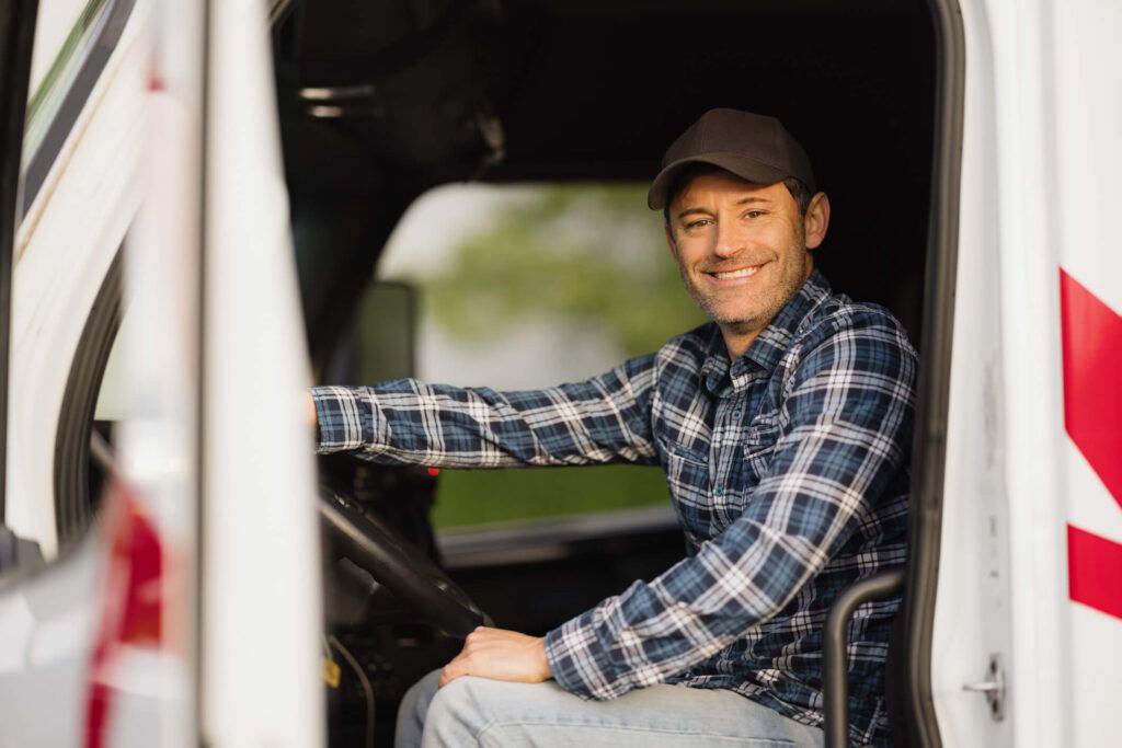 A fleet driver happily gets in the cab of his truck.