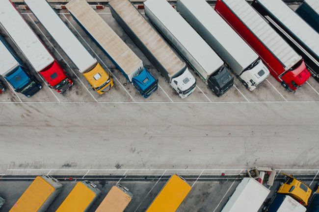 An aerial view of a fleet of semi trucks parked at perfect angles.